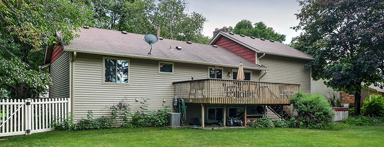 The back of a home with a deck.